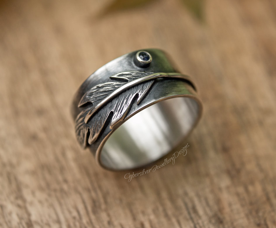 Wide silver feather ring with blue sapphire